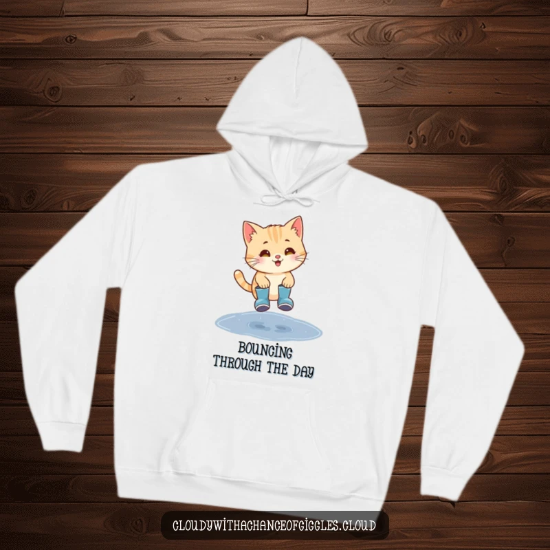 Funny cat in tiny rain boots jumping over a puddle, a cozy and humorous hoodie.